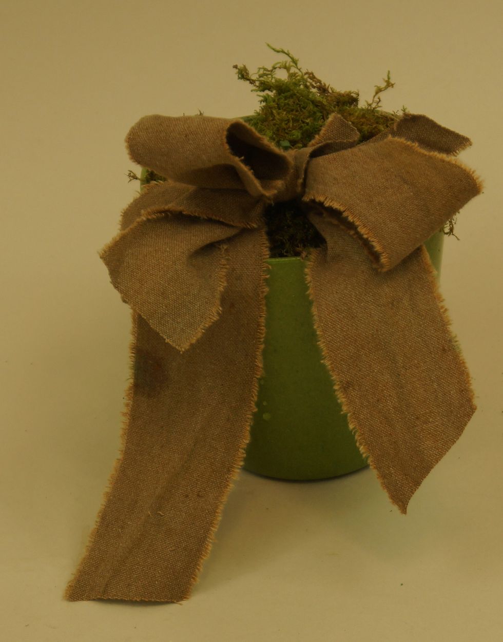 Cover foam with sheet moss and add a decorative bow using OASIS\u2122 Raw Muslin