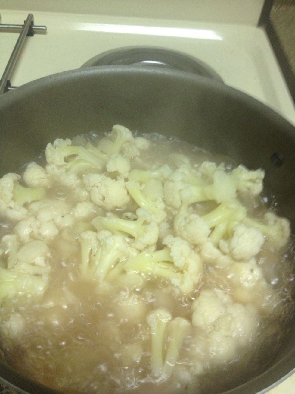 Cover half way with water and bring to a boil. Once it boils cover and bring to a low simmer until the cauliflower is fork tender.