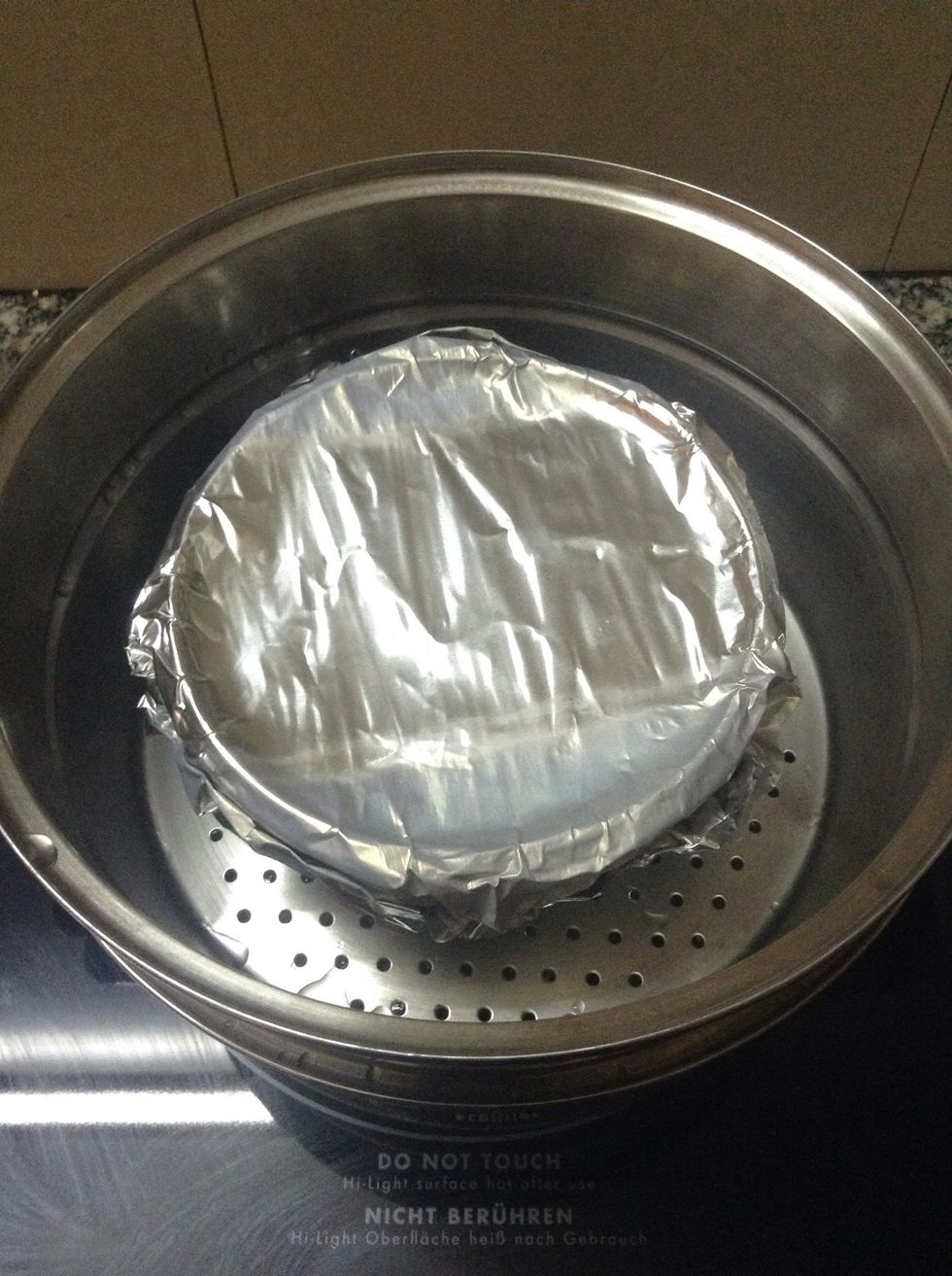 Cover it with aluminum foil in order not to let any water go in the flan. Here I use the double-boil method. You can check the other method on the internet to decide which one suits you the most.