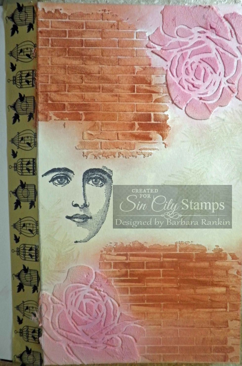 Cover rose at bottom with rose mask. Stamp pine bough onto page, as shown, using Versamark ink. Do the same with the rose at the top, and stamp over the bricks as well.
