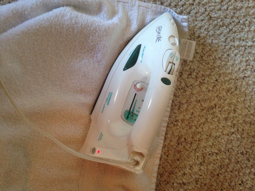 Cover stain with white towel (using a white towel keeps any color dyes off your carpet), iron over stain.