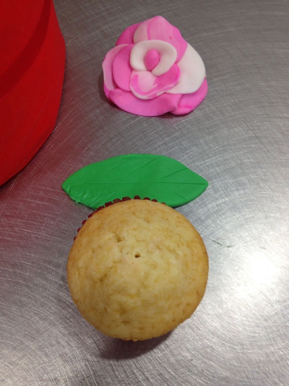 Cover styrofoam with material. Make leaves & fondant flowers or get ready made ones :) you can also decorate them with Buttercream. What ever you prefer ;)