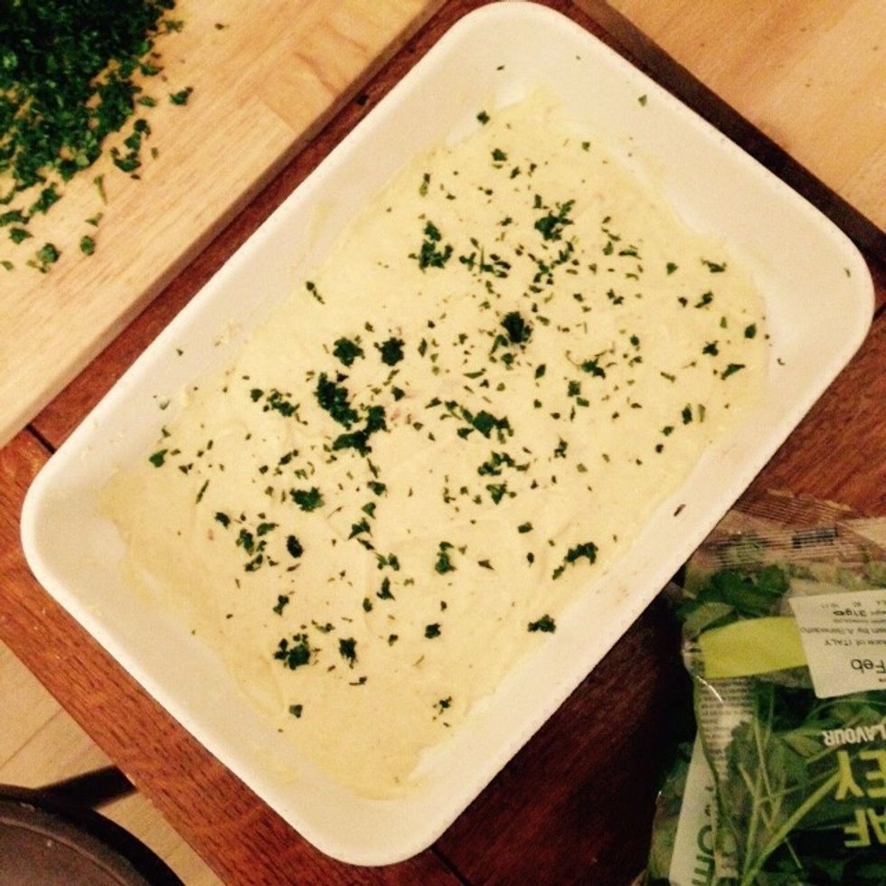 Cover the bottom of one baking tray with b\u00e9chamel and sprinkle some parsley on top