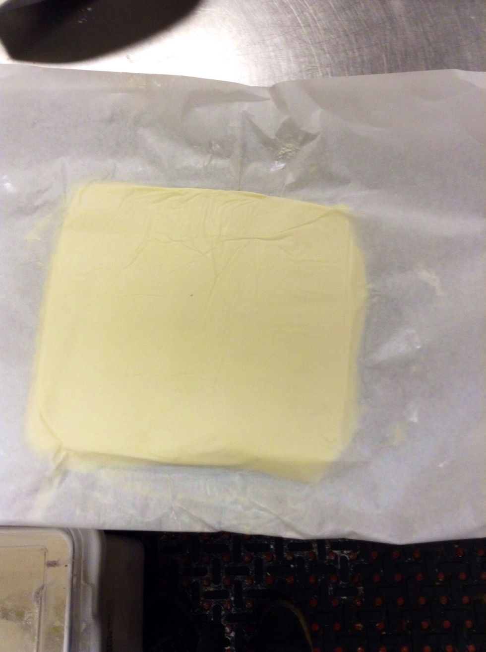 Cover the butter top and bottom with the wax paper. Roll the butter out, keeping the square/rectangular shape until it is about 1/4-1/2 an inch thick. Place in fridge until it is cooled and hard again