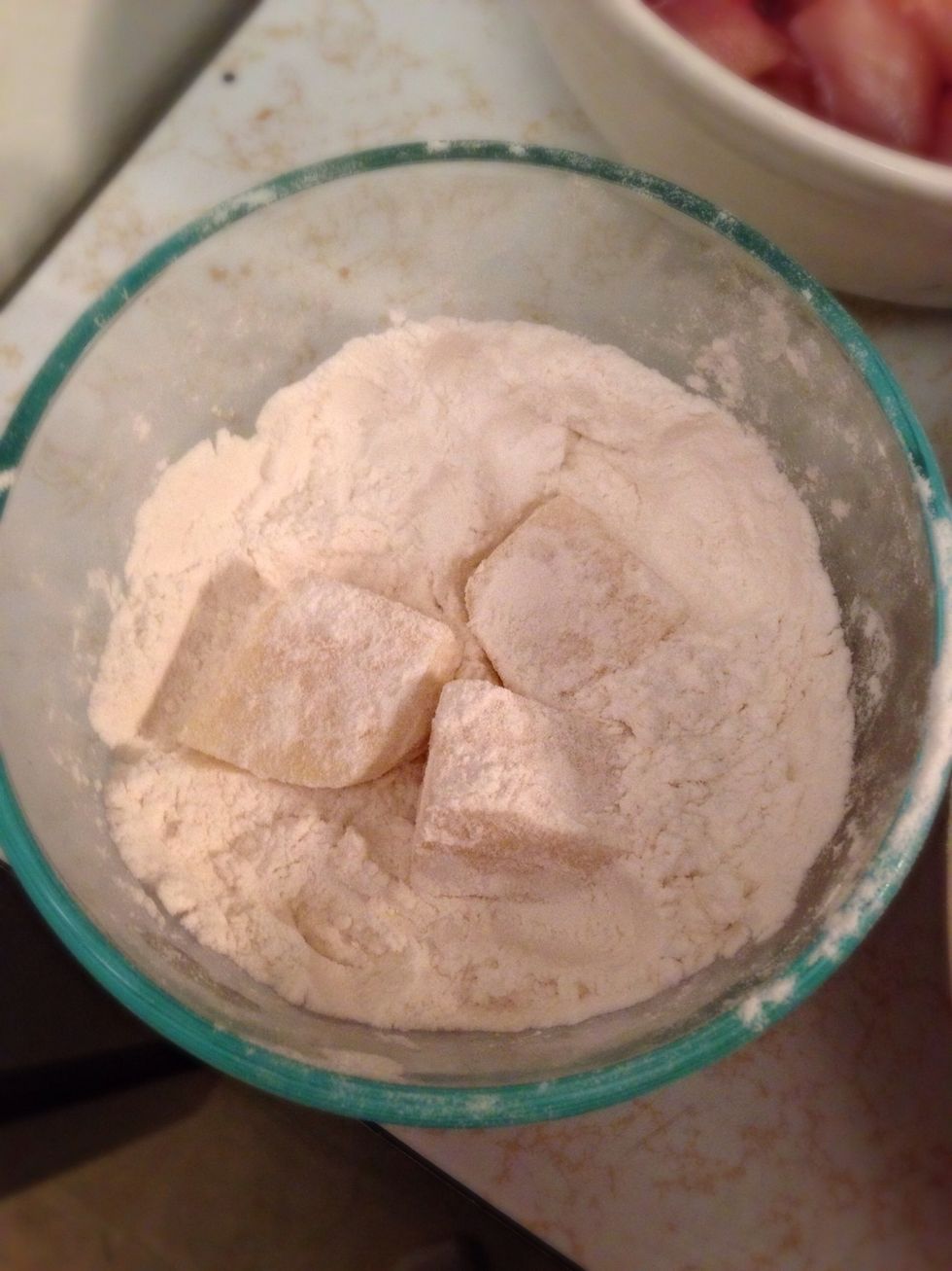 Cover the cheese cubes in flour, shake off excess flour and throw them in your egg bowl.