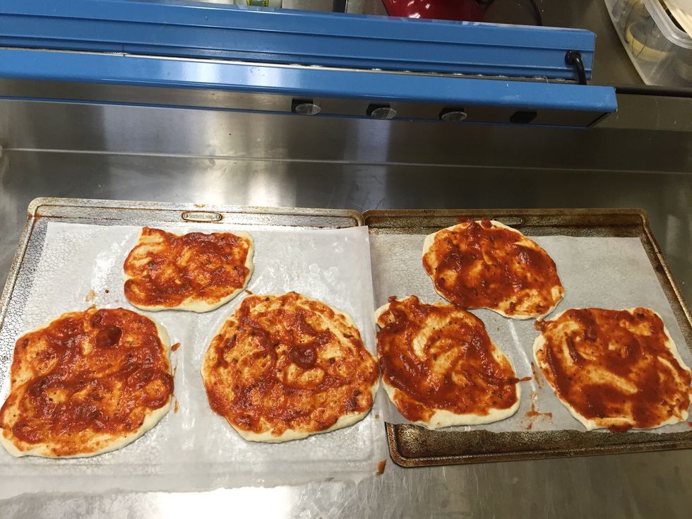 Cover the dough in the spaghetti sauce.