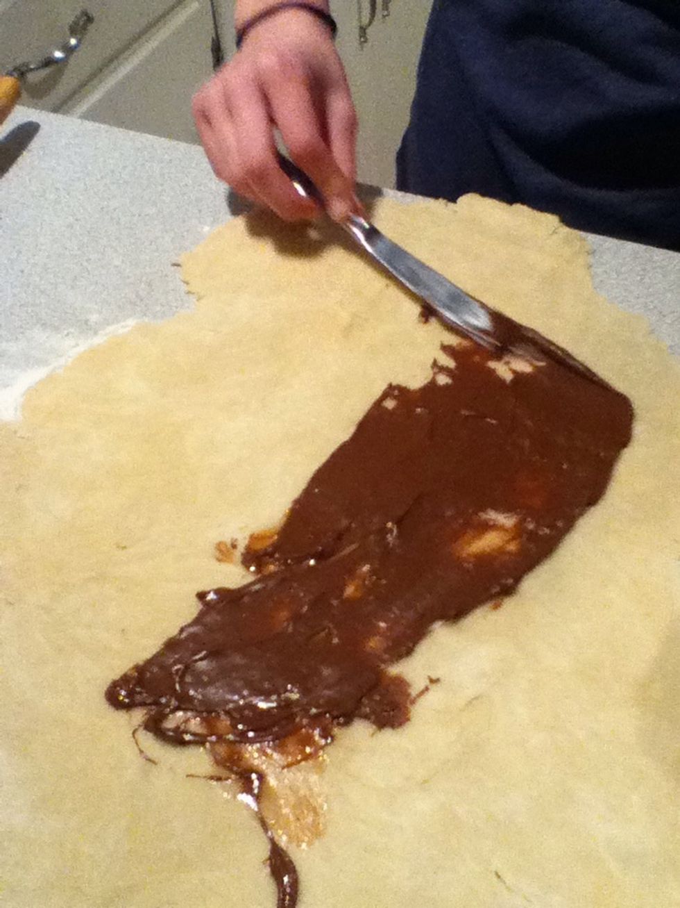 Cover the dough with chocolate spread.