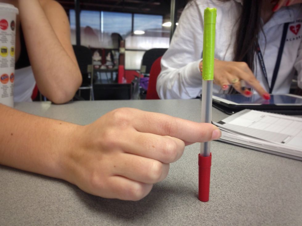 Cover the end of your pen with the piece of tape that you cut.