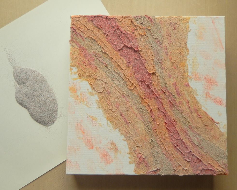 Cover the paste on the canvas with the 'rusting' mix of embossing powders, tapping off the excess and setting with a heat tool.