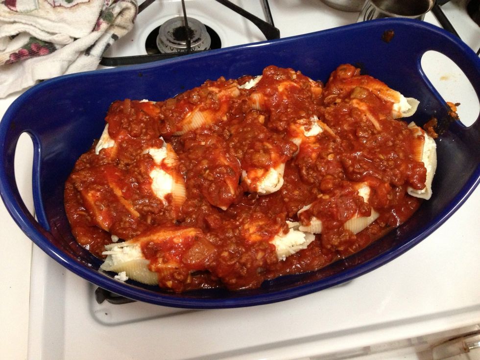 Cover the stuffed shells with sauce.