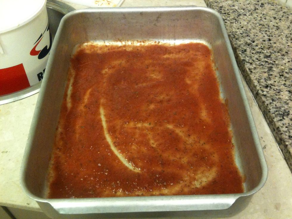 Cover the tray with pizza sauce.