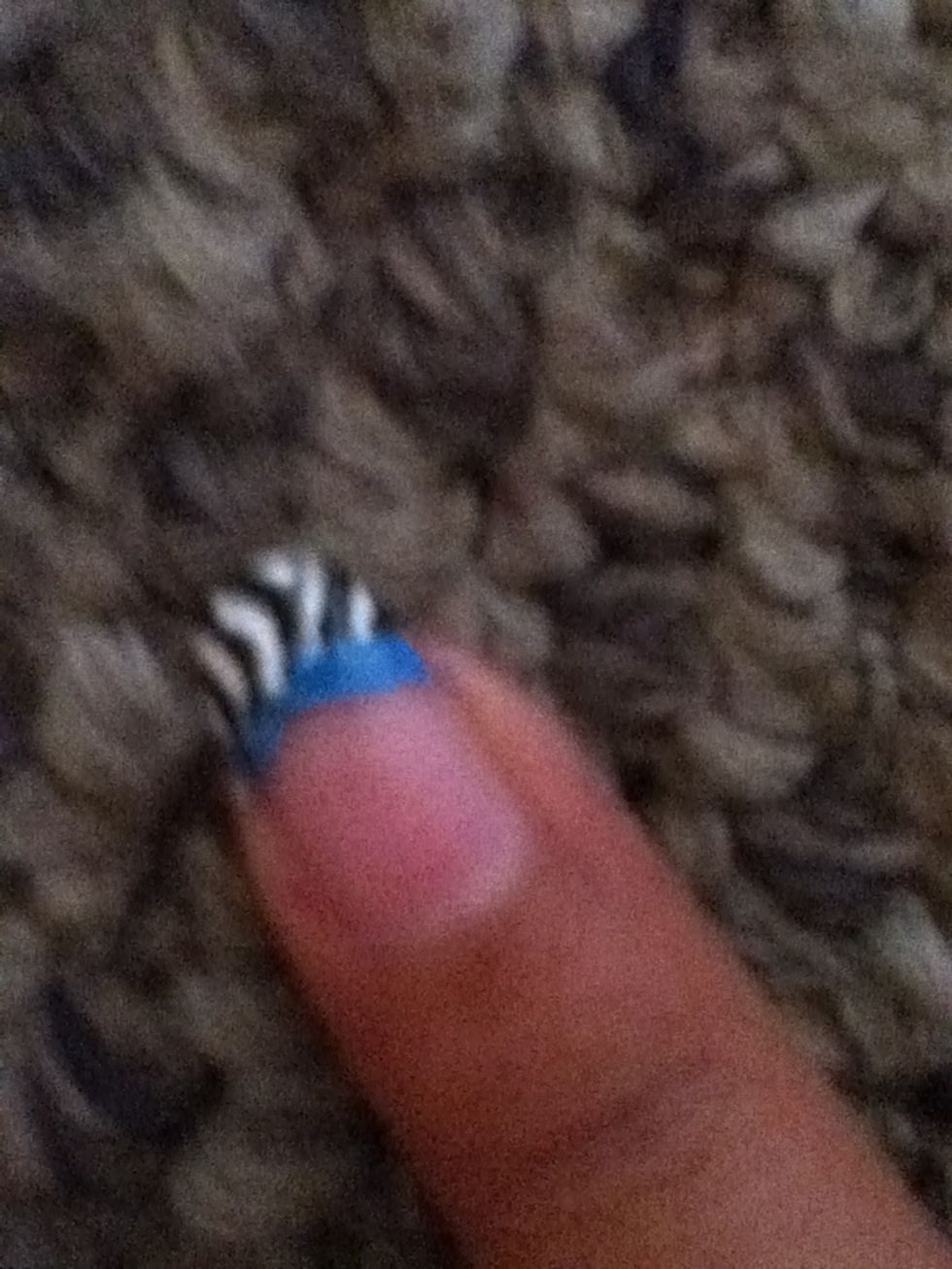 Cover the whole tip with zebra stripes and with ur striper make a blue line on the bottom of ur French tip