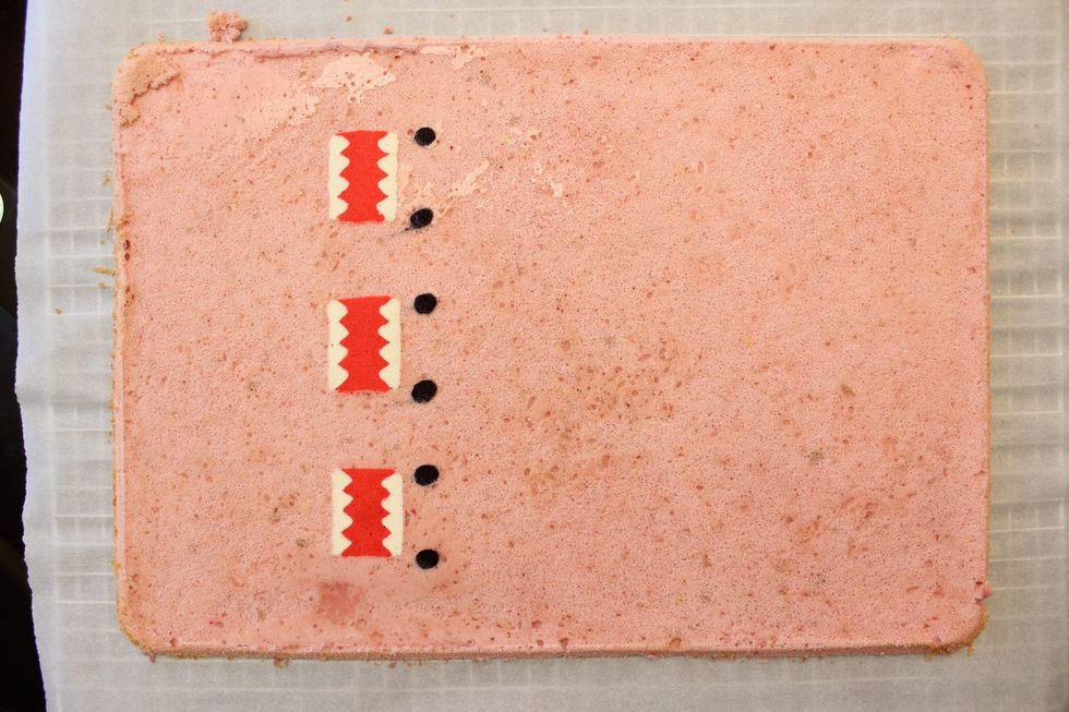 Cover with another sheet of parchment paper and then with another cooling rack (or the bottom side of your cake pan) and flip over!