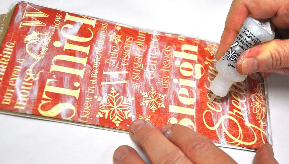 Cover your tag with a piece of "Merry Mistletoe". Use your finger to add some gesso and trace over some of the words with stickles.