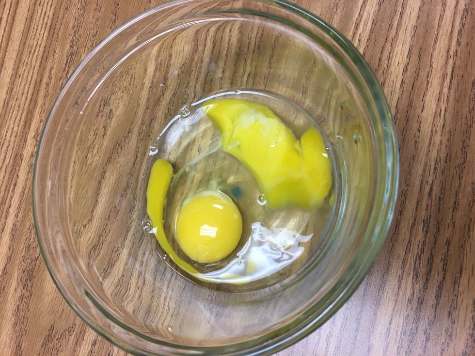 Crack 2 eggs in a custard cup.