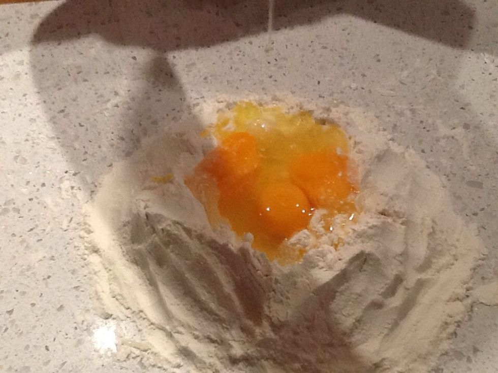 crack all of the eggs into the well and add the salt.