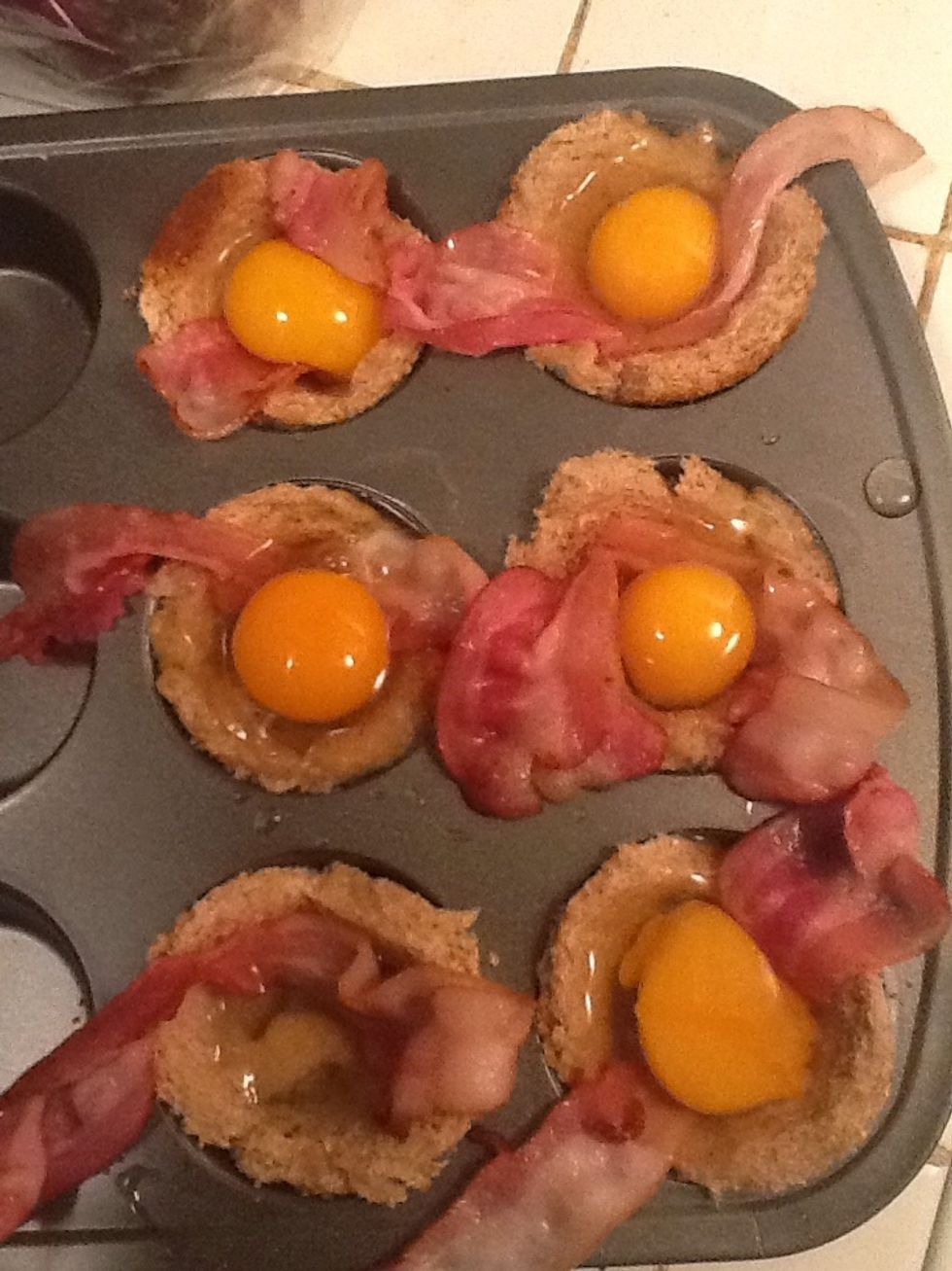 Crack an egg over each cup.