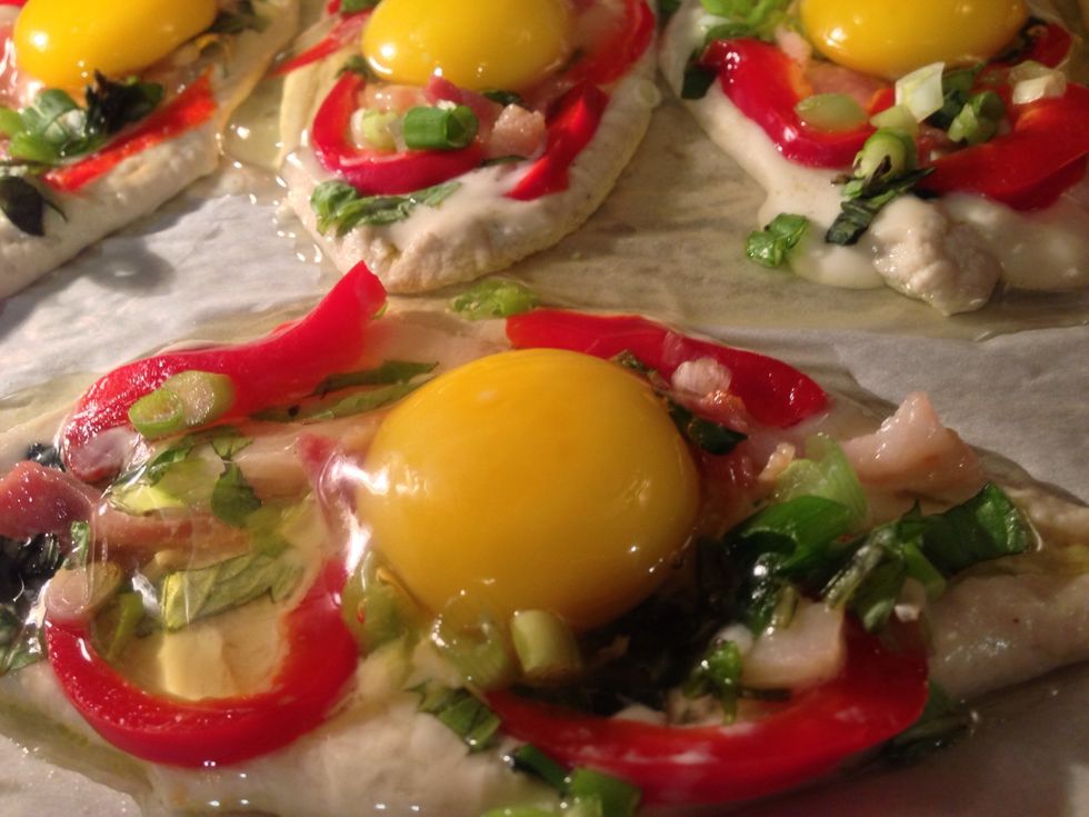 Crack and drop the egg in the middle on each. You may see some of the egg white spill to the edge , that's ok as long as the yolk stays in the middle .