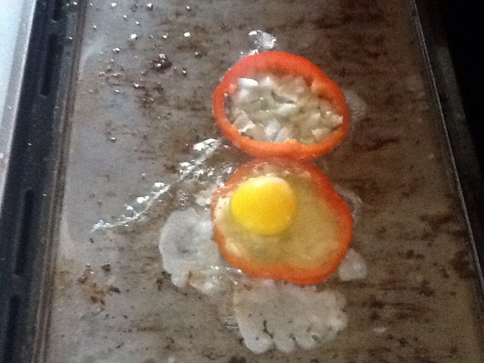 Crack eggs and pour one into each prepared bell pepper ring.