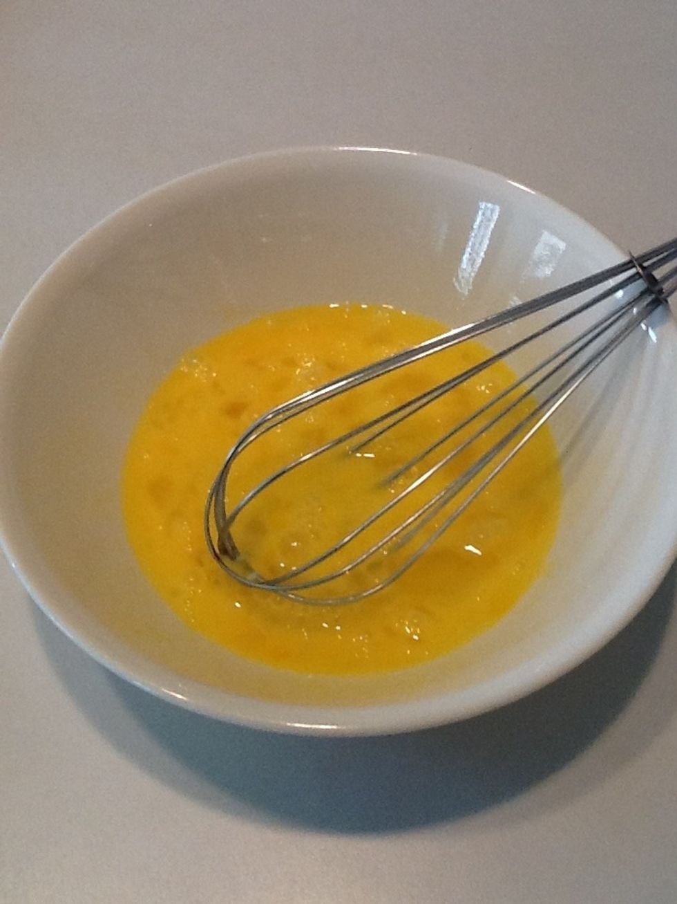 Crack eggs into a bowl and whisk.