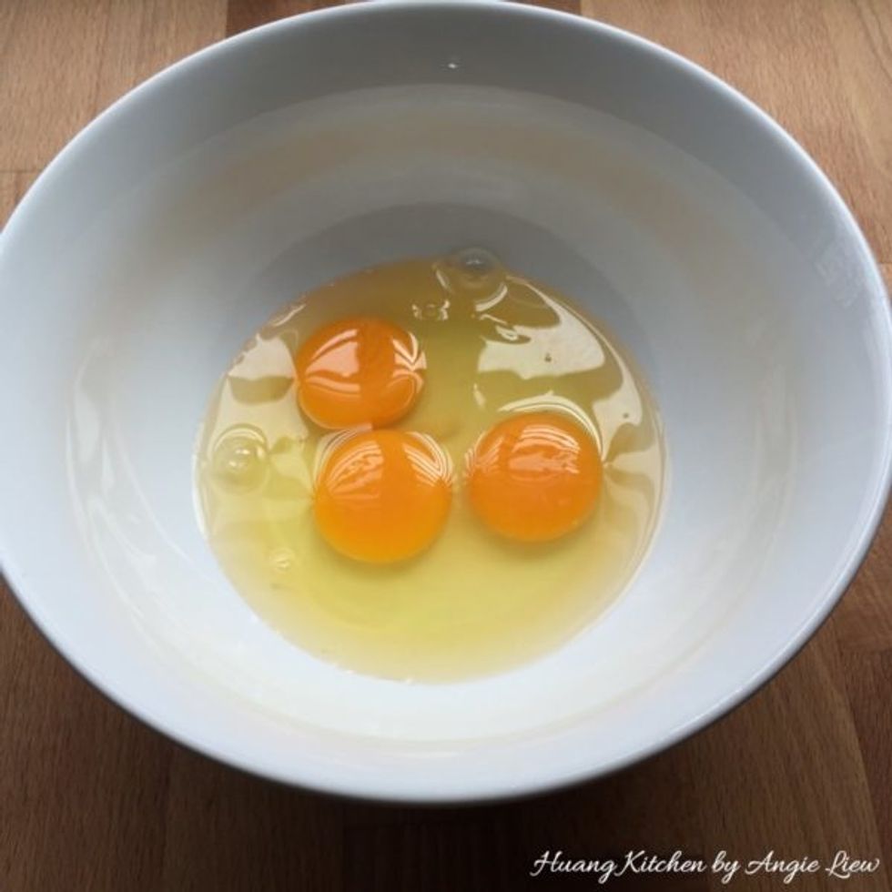 Crack three eggs into a large bowl.