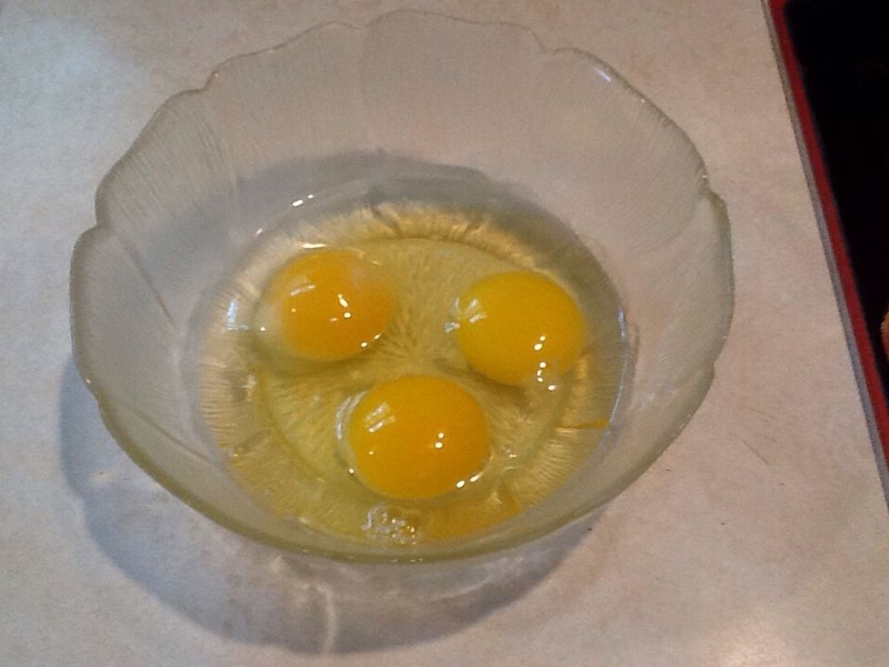 Crack three eggs into the bowl.