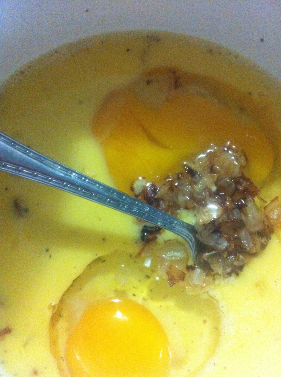 Crack your eggs into a bowl, add your browned onions, some black pepper, and a splash of milk and beat together.