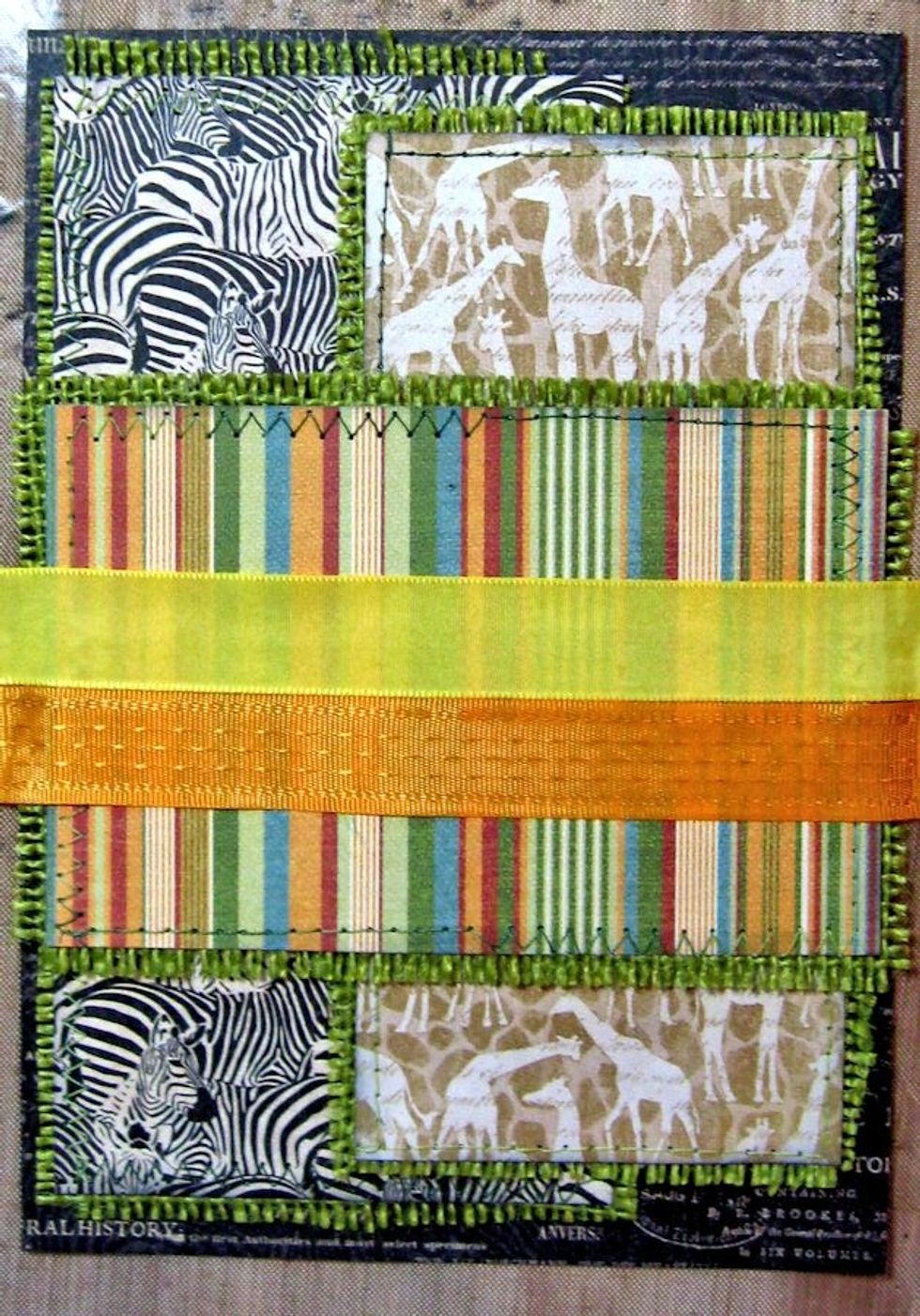 Create a 4 1/2" wide x 2.75" tall belly band with Serengeti Outfitters strip. Stitch onto green burlap. Wrap with Maize & Tangerine Delicate stitch Satin ribbon. Glue in place as seen here.