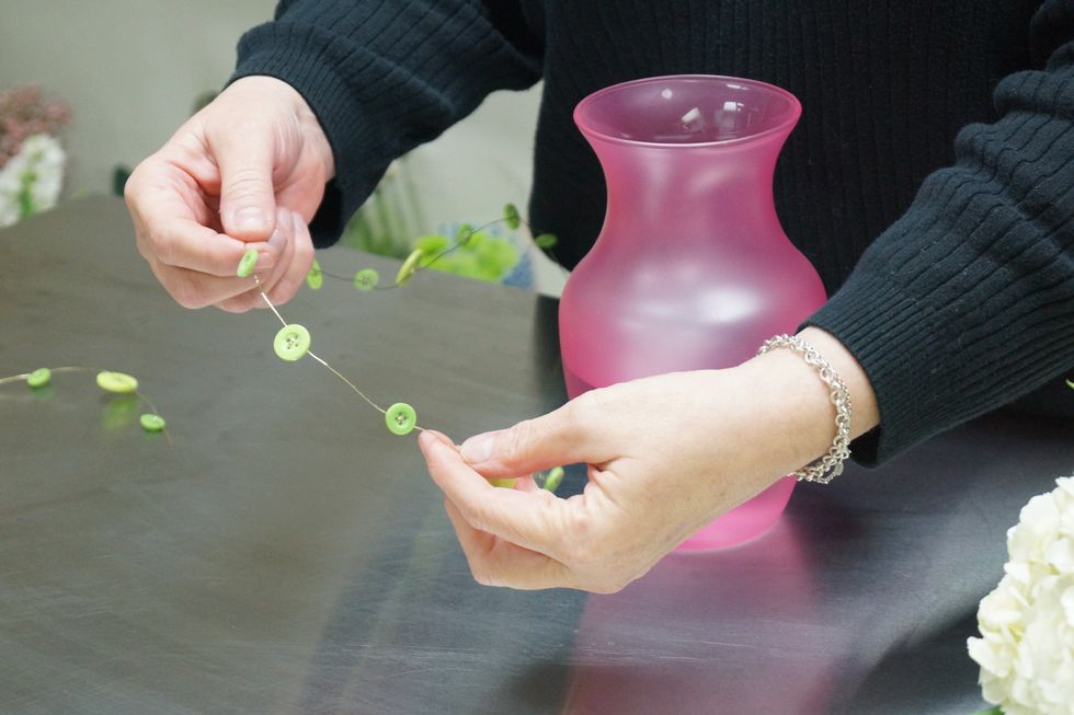 Create a bow of button wire, starting with a loop, pinching the center, and continuing in a figure eight pattern. When there is 1 ft. remaining, wrap around center of the bow securing the bow shape.