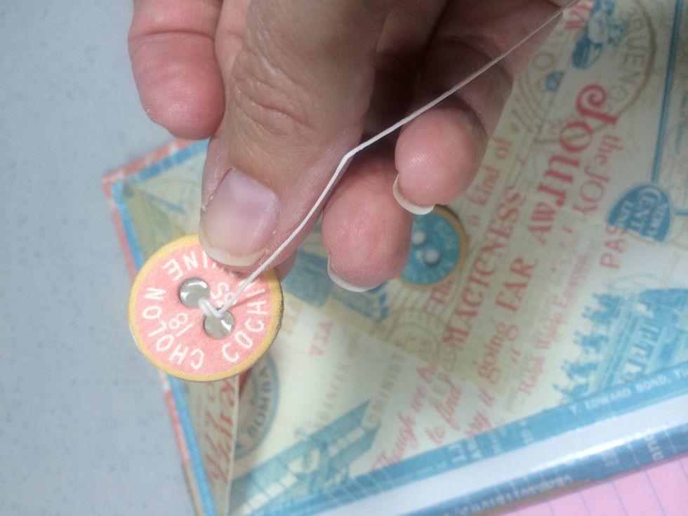 Create a closure for the envelope by inserting a 16" piece of waxed twine through a chipboard button.