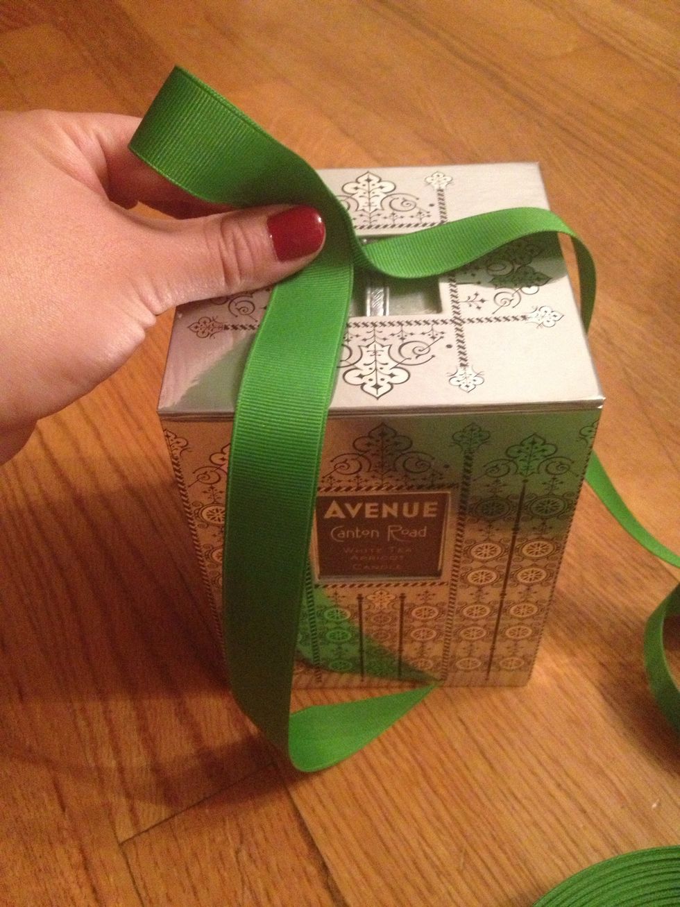 Create a loop with your ribbon with two fingers.  Eyeball it, making it as large as you'd like the final bow to be.  Leave the start of the ribbon just long enough to hang down the side of the box.