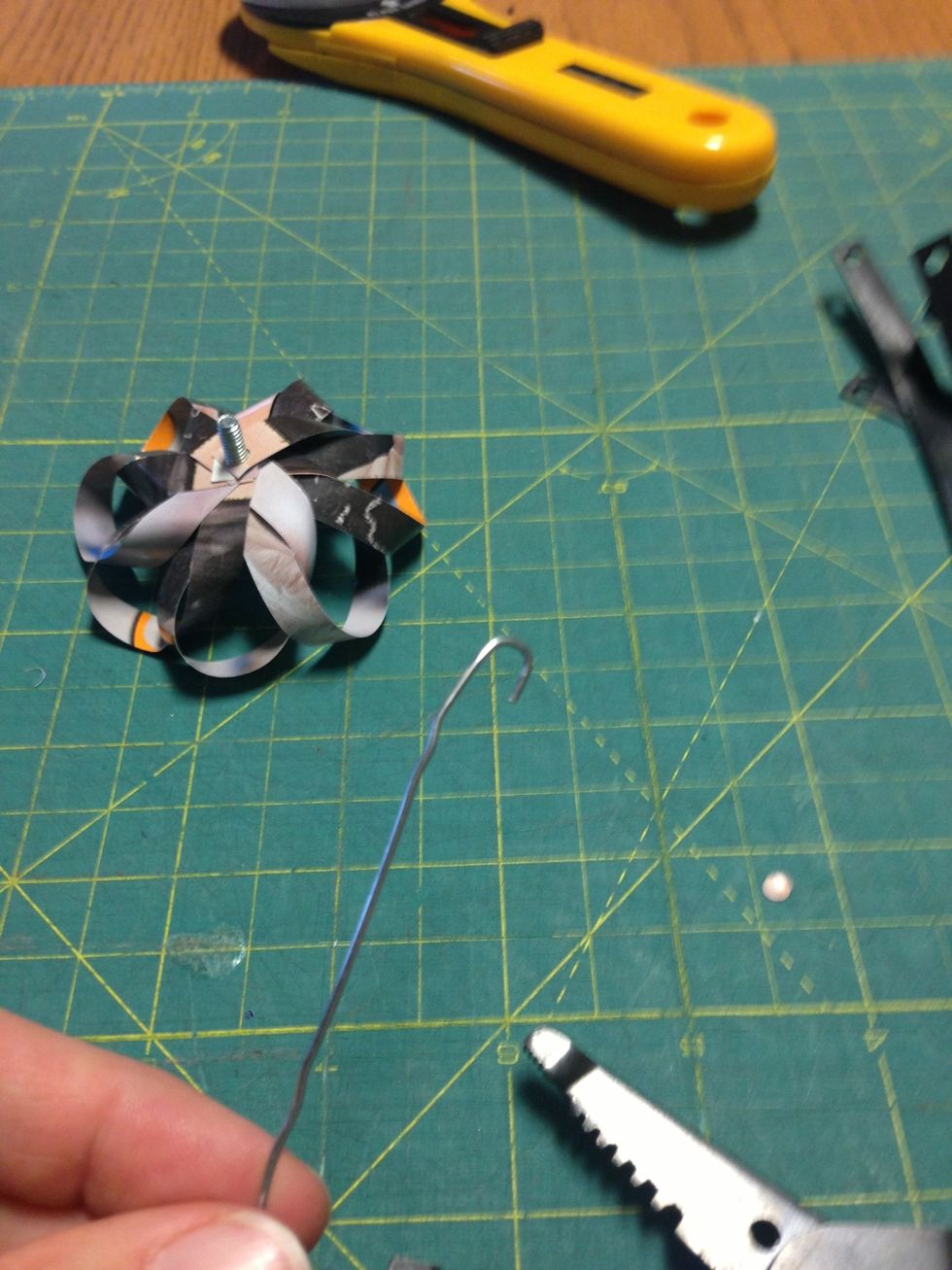 Create a small loop at one end of the paper clip to wrap around the bolt.