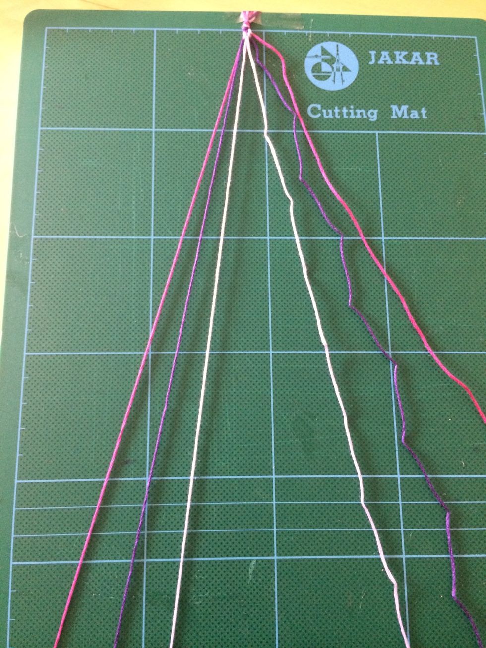 Create another double knot. Repeat on the purple thread and create a double knot. The lilac threads will be in the centre positions.
