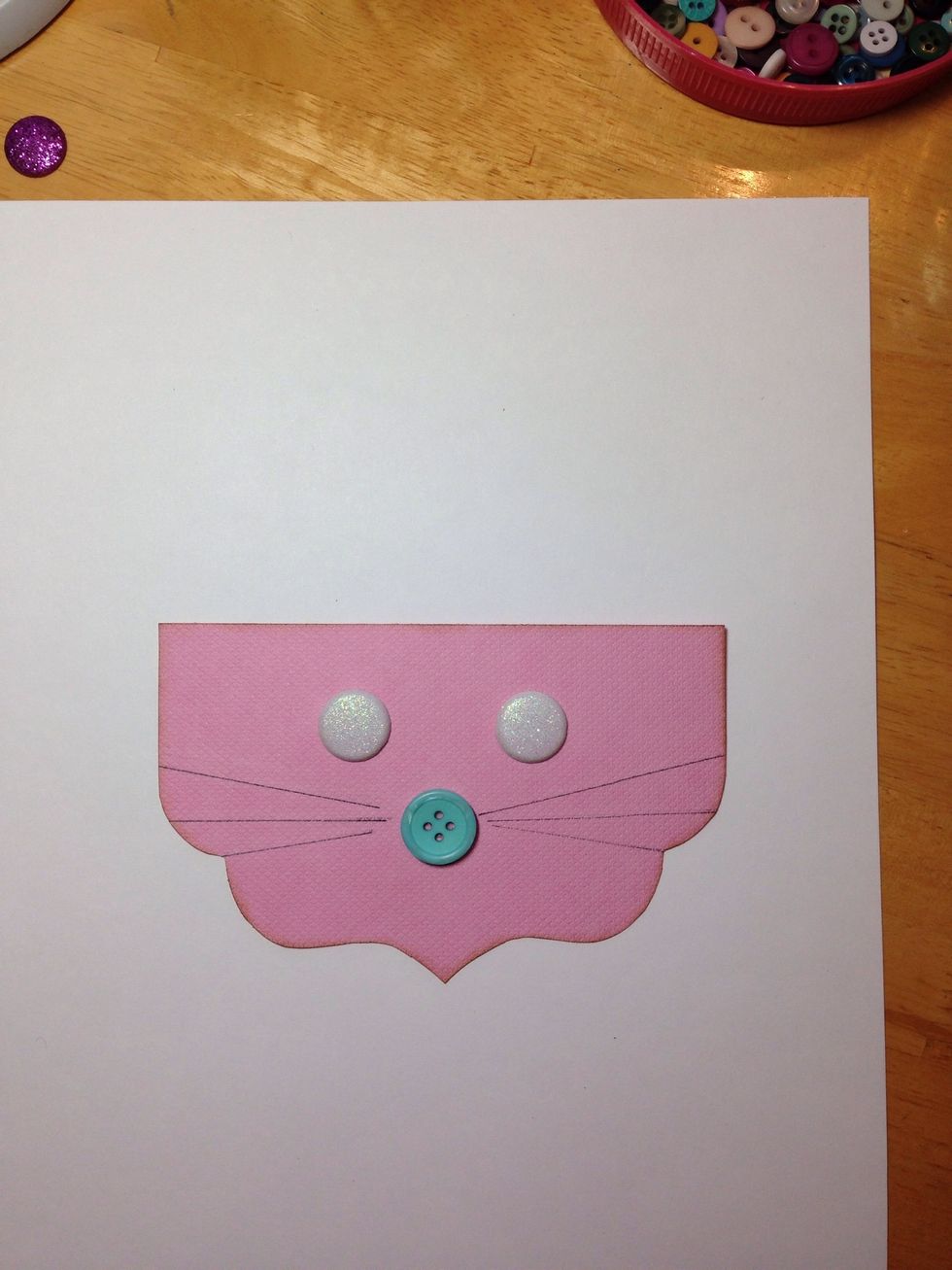 Create the bunny face on the other bracket with buttons or brads. Draw some whiskers.