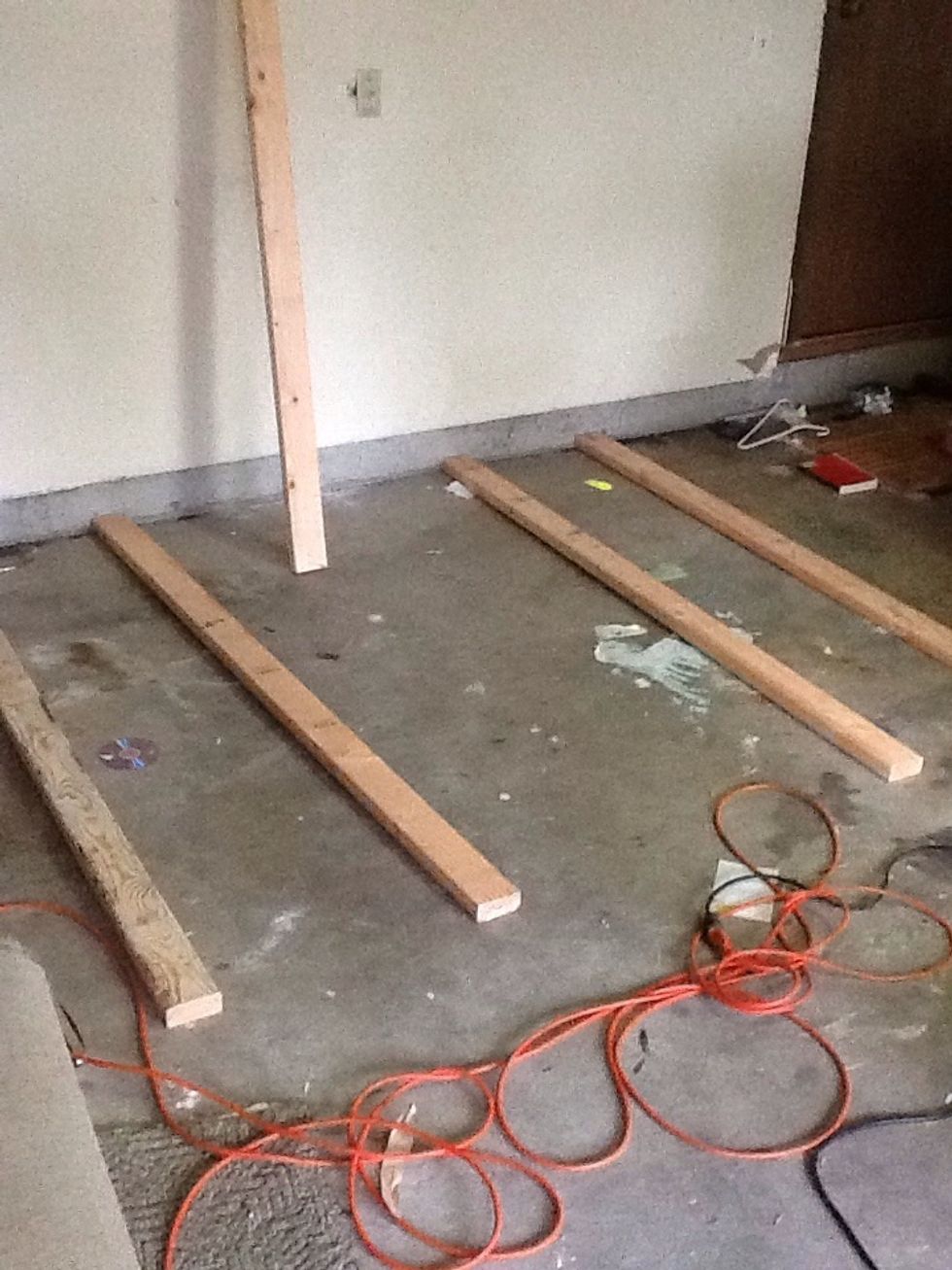 Create the 'frame' of the shelving unit on the floor in front of the stud you just drilled into the wall. These will be the exposed legs of the top shelf.