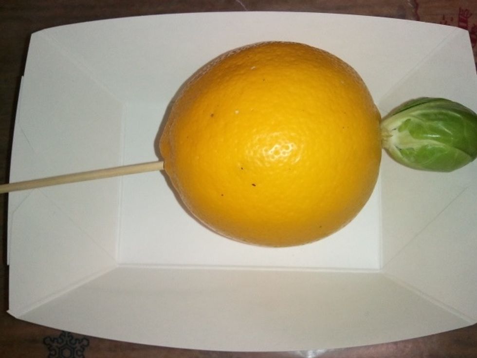 CREATE THE PHARAOH - Starting from the bottom of the citrus, insert the pointed end of the skewer all the way through the fruit and halfway through the head.  Leave the point embedded in the head.