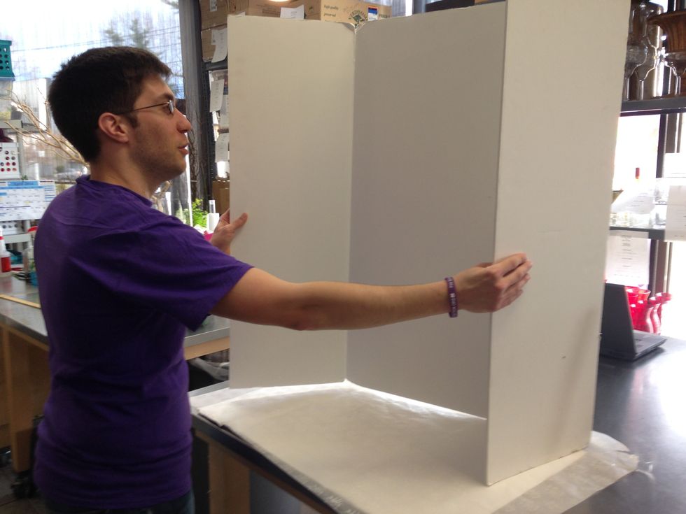 Create your set. In this example we were able to create a smooth white background using white tri-fold poster board and a white piece of tissue paper.