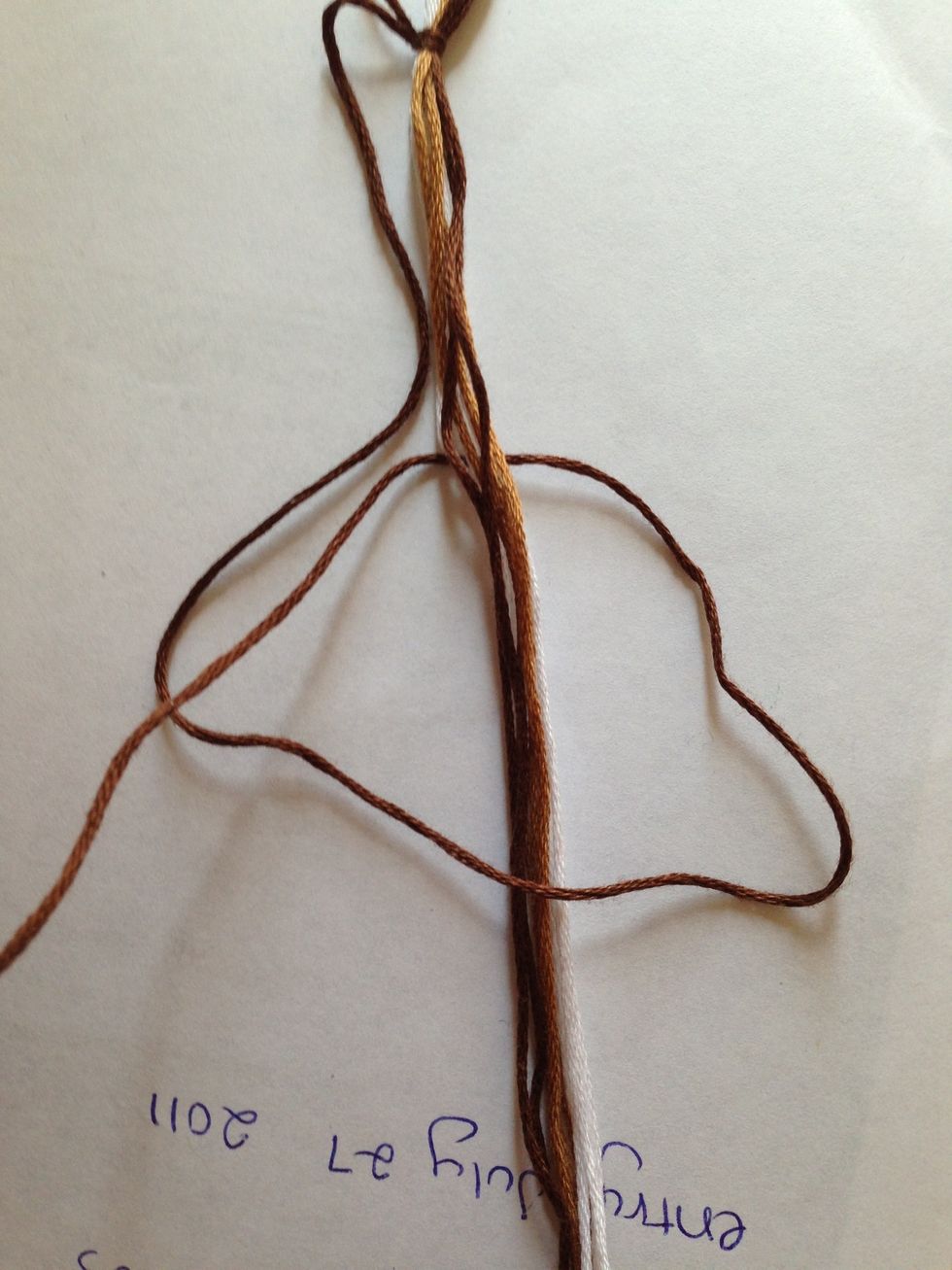 .... cross it back under the rest of the strings, and pulling it up...