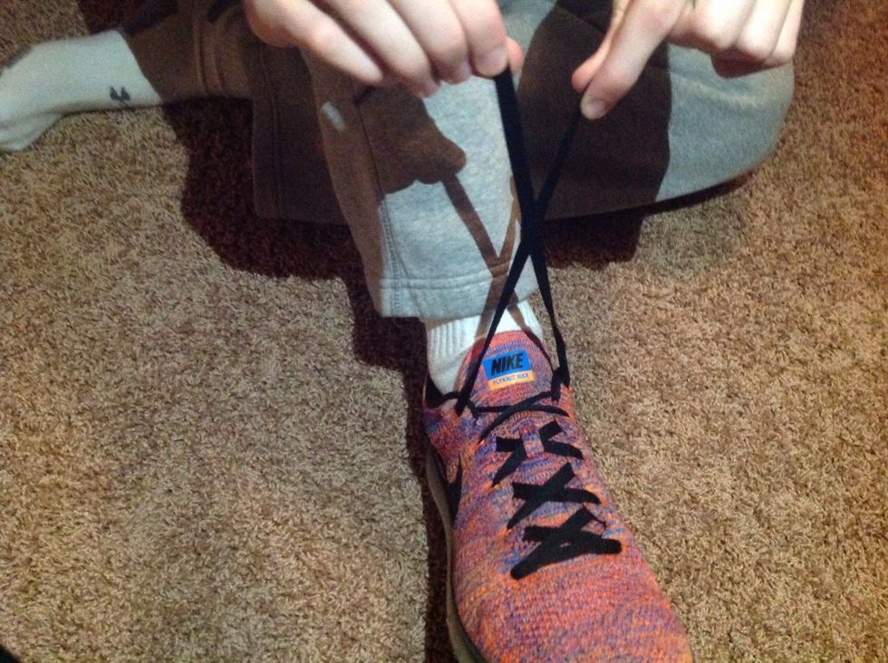Cross the laces so they form an X shape.