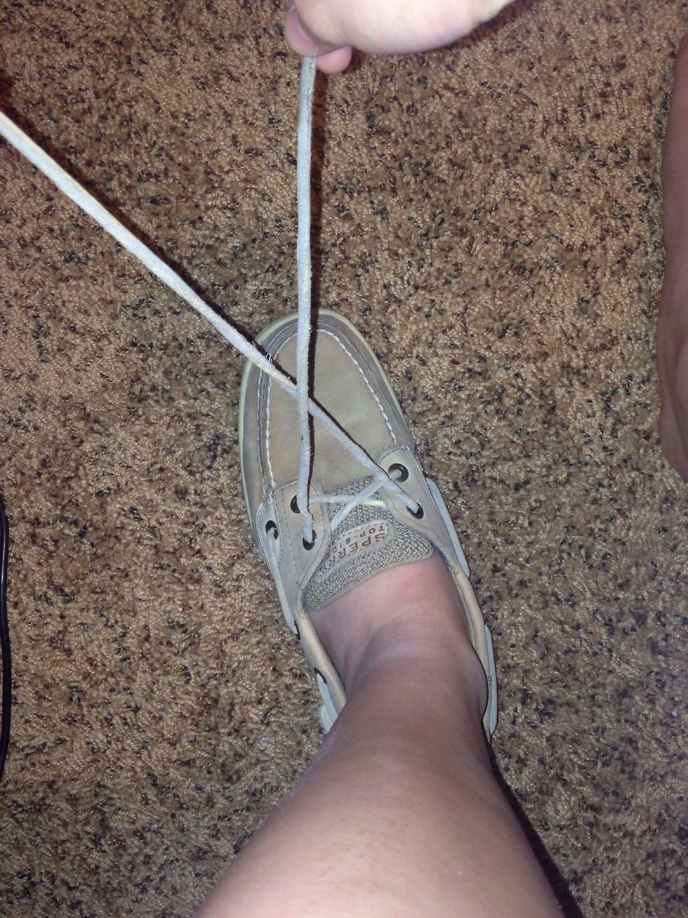 Cross your two laces over one another, making an X.