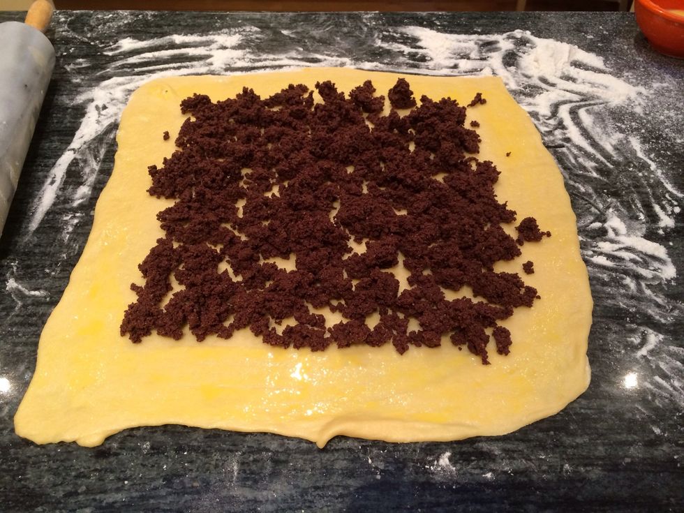 Crumble approximately 1/3 of the reserved chocolate filling evenly over dough, leaving a 1/4 inch border at the edges.