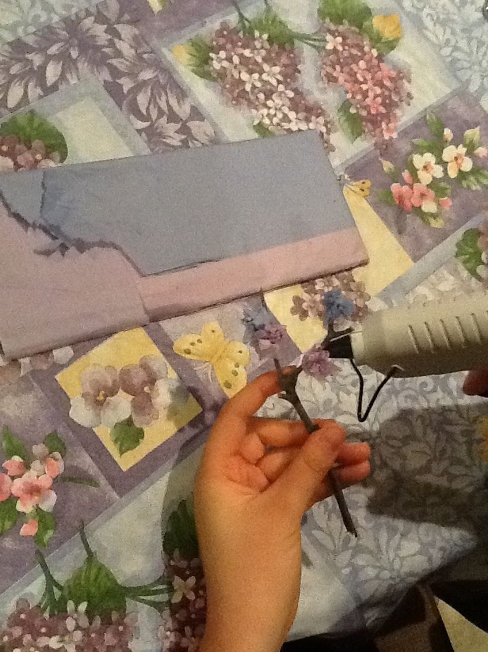 Crumple pieces of tissue paper (a little messy is fine) and glue to the branch with a hot glue gun, closer to the ends of the twig, giving an appearance of a budding flower. Let it the glue cool.