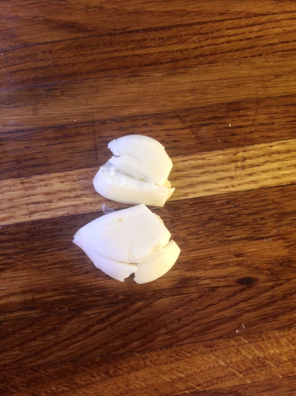 Crush 2 cloves of garlic with the palm of your hand. And add to the saucepan.