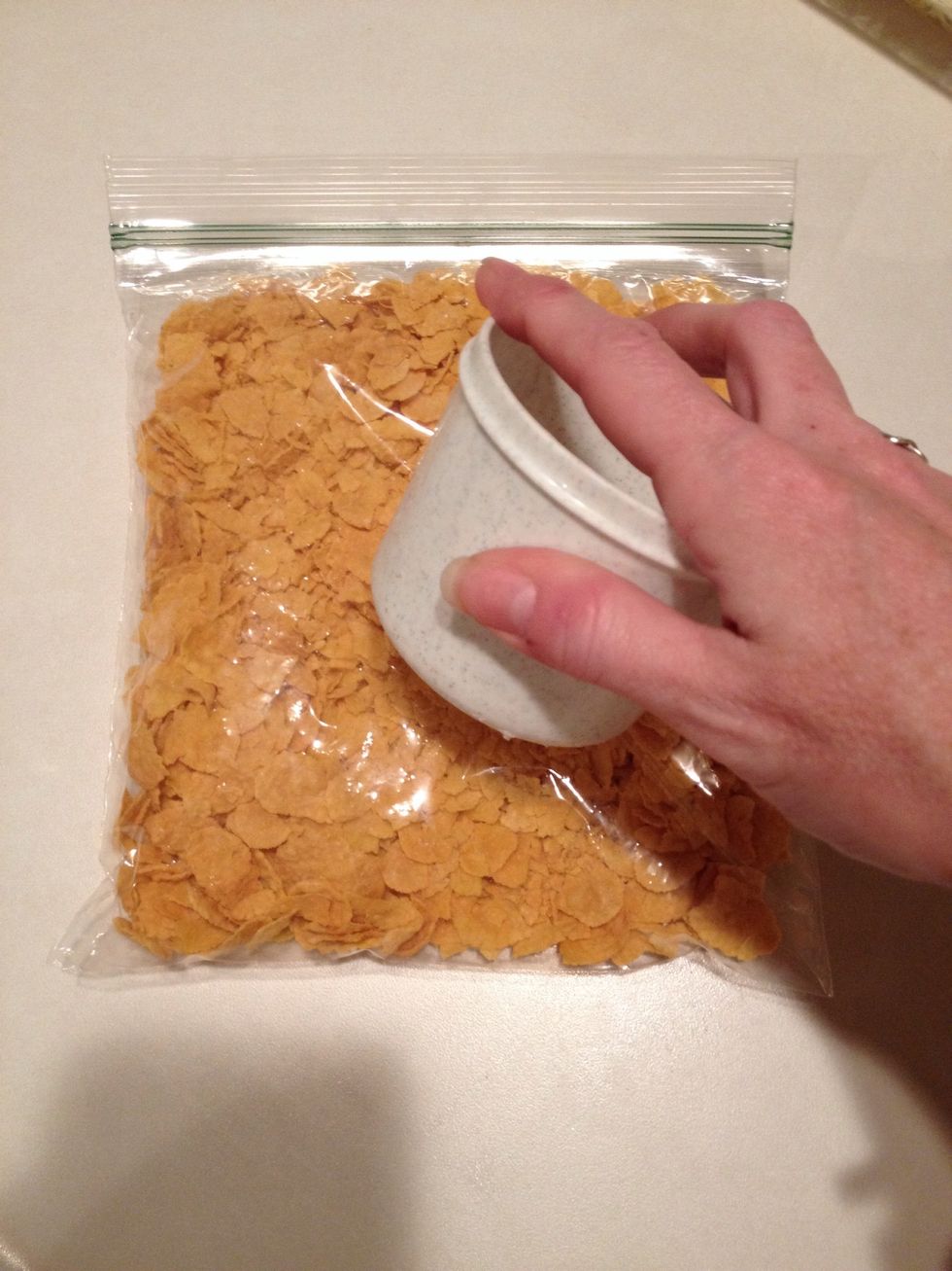 Crush corn flakes in a ziplock bag using the bottom of a spoon or measuring cup.