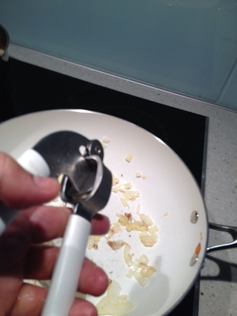Crush garlic into pan.