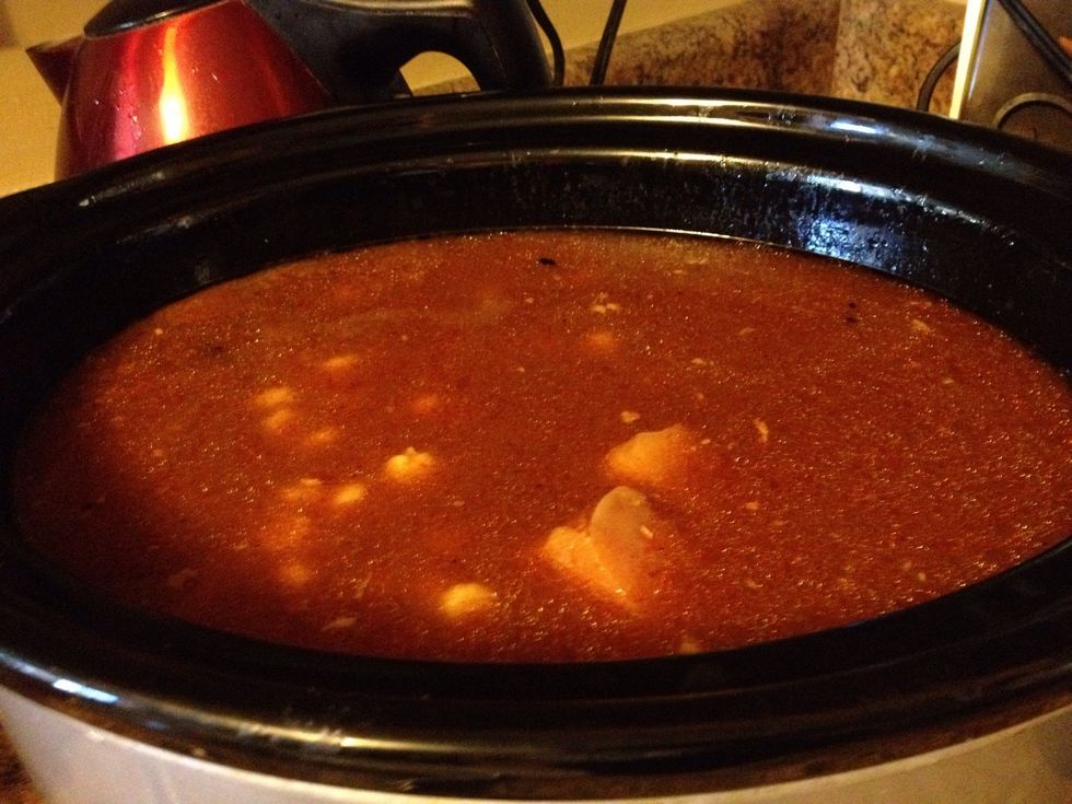 Cube chicken. Add to slow cooker with chicken stock and one can enchilada sauce plus drained hominy. Cook on LOW 8 hours. Then add second can of sauce, heat 10 min and serve.