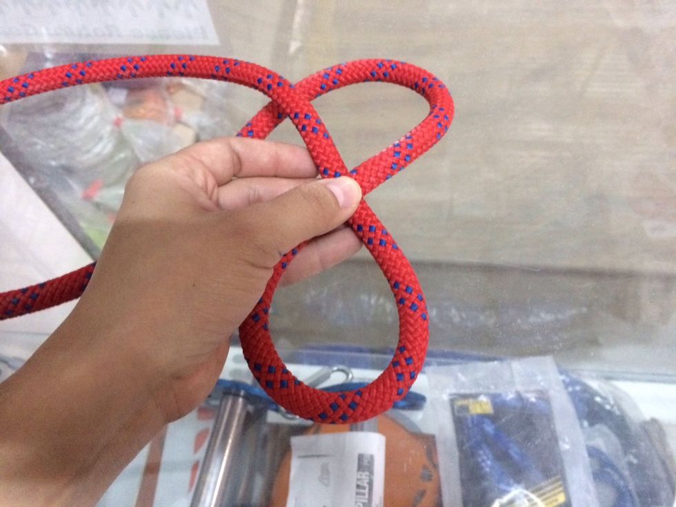 Curl the remainder of the short side (tag end) of the rope under the long side (load strand) of the rope so it looks like the number 8.