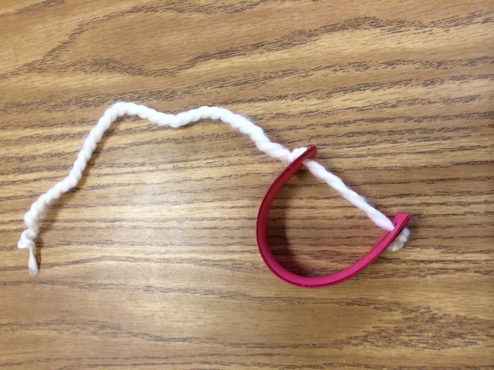 Curve the strips in a "c" shape and lace the string through the other holes. Tie a knot at the top.