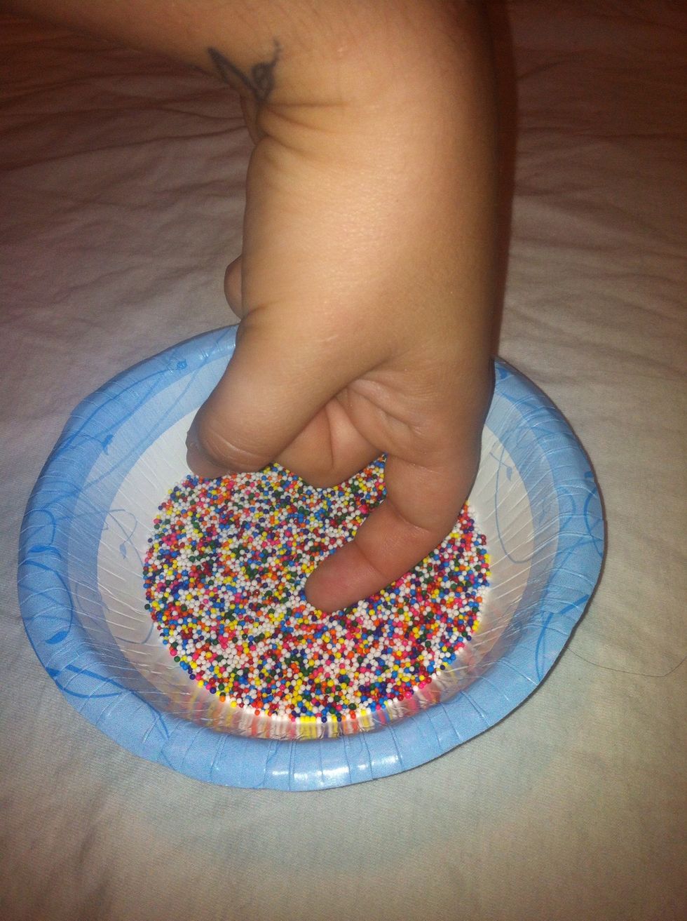 Curve your finger into a hook shape and dip into the sprinkles; this will ensure the entire nail is covered. Be sure not to hit the bottom of the bowl.