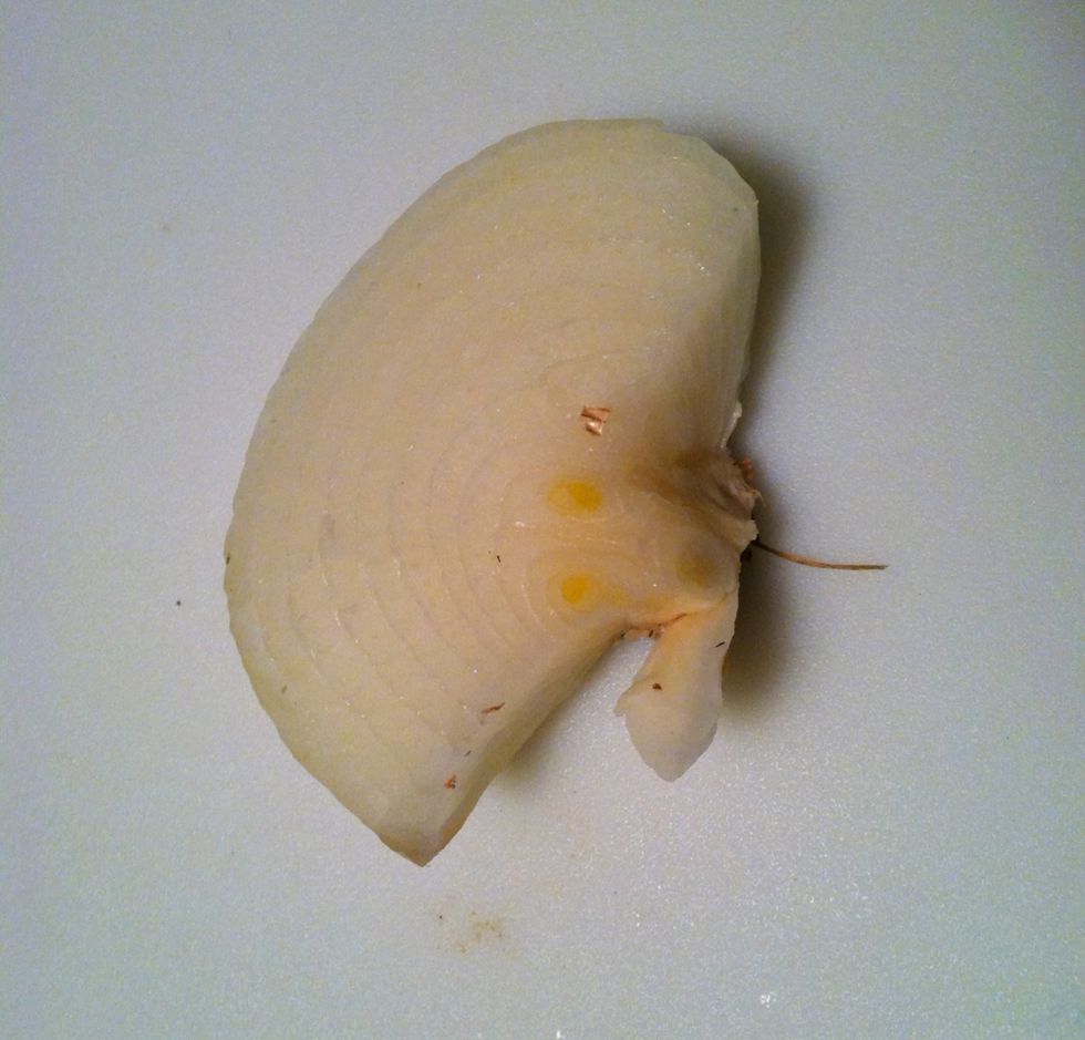 Cut 1/4 of an onion at the root end so it will not separate. Place in a pot of water and bring to a boil. Add 1 teaspoon of salt - optional.